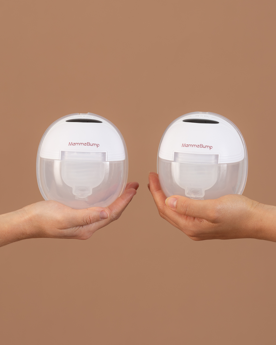 Two hands holding the luna wearbale breast pumps.