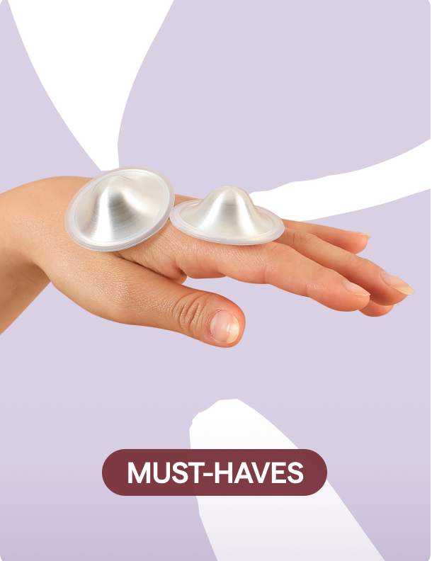 Hands holding silver nursing cups silverette on lavender background