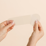 Close-up of hands demonstrating the soft, flexible texture of a MammaBump C-Section Silicone Scar Strip for scar care