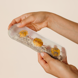 Close-up of hands demonstrating the MammaBump Perineal Hot & Cold Therapy Pack with chamomile and lavender inside for postpartum recovery