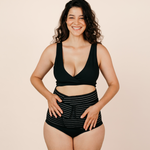 Smiling new mum confidently wearing the black MammaBump Postpartum Belly Band high-waisted for gentle support during postpartum recovery