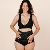 Smiling new mum confidently wearing the black MammaBump Postpartum Belly Band high-waisted for gentle support during postpartum recovery