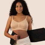 New mum holding the black MammaBump Postpartum Belly Band against her body, showing real postpartum belly and the gentle support ahead in her recovery