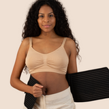 New mum holding the black MammaBump Postpartum Belly Band against her body, showing real postpartum belly and the gentle support ahead in her recovery
