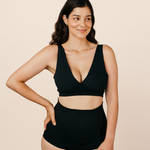 Mum wearing MammaBump Postpartum Soothing Briefs in black, high-waisted and seamless, paired with a black nursing bra
