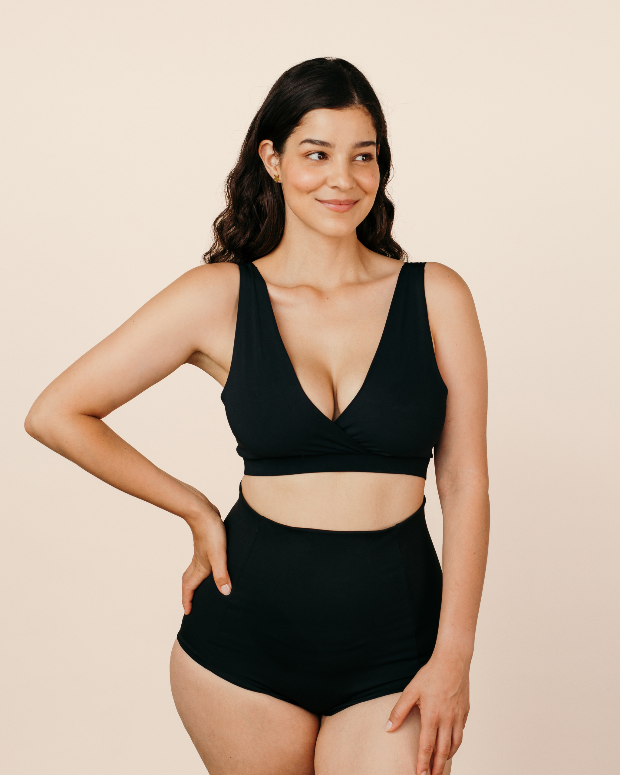 Mum wearing MammaBump Postpartum Soothing Briefs in black, high-waisted and seamless, paired with a black nursing bra