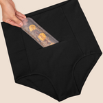 Hand placing the MammaBump Perineal Hot & Cold Therapy Pack into the pocket of the Postpartum Soothing Brief for gentle perineal relief during postpartum recovery
