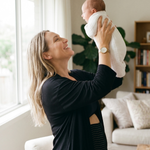 postpartum-mom-wearing-belly-band-lifting-her-baby