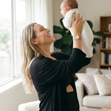 postpartum-mom-wearing-belly-band-lifting-her-baby